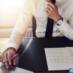 Man sitting at table with laptop and documents